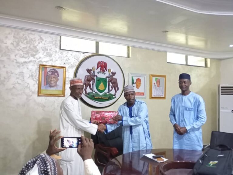 Sunusi Kofar Na'isa receiving gift from PS Dr Hadi